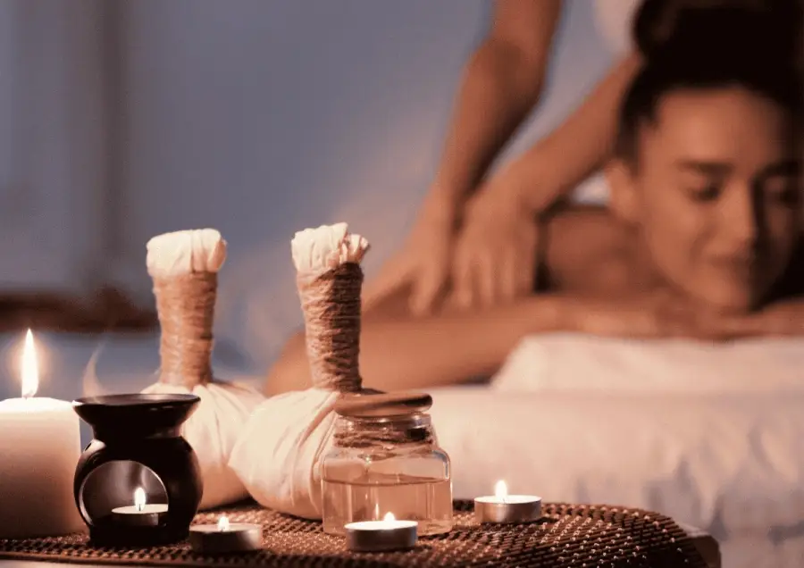 Signature massage setting with candles and oil bundles