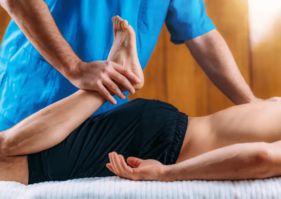 Therapist giving a sports massage to a leg