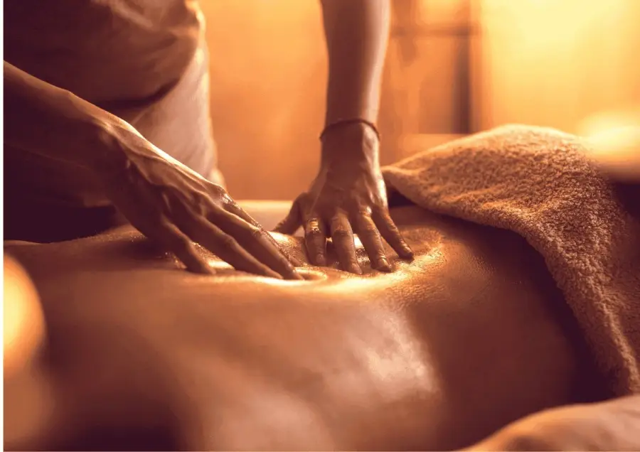 Hands giving a Swedish massage with warm oil